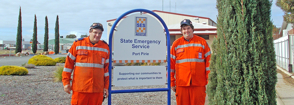 SA State Emergency Service volunteers standing beside a sign outside the Port Pirie Unit building